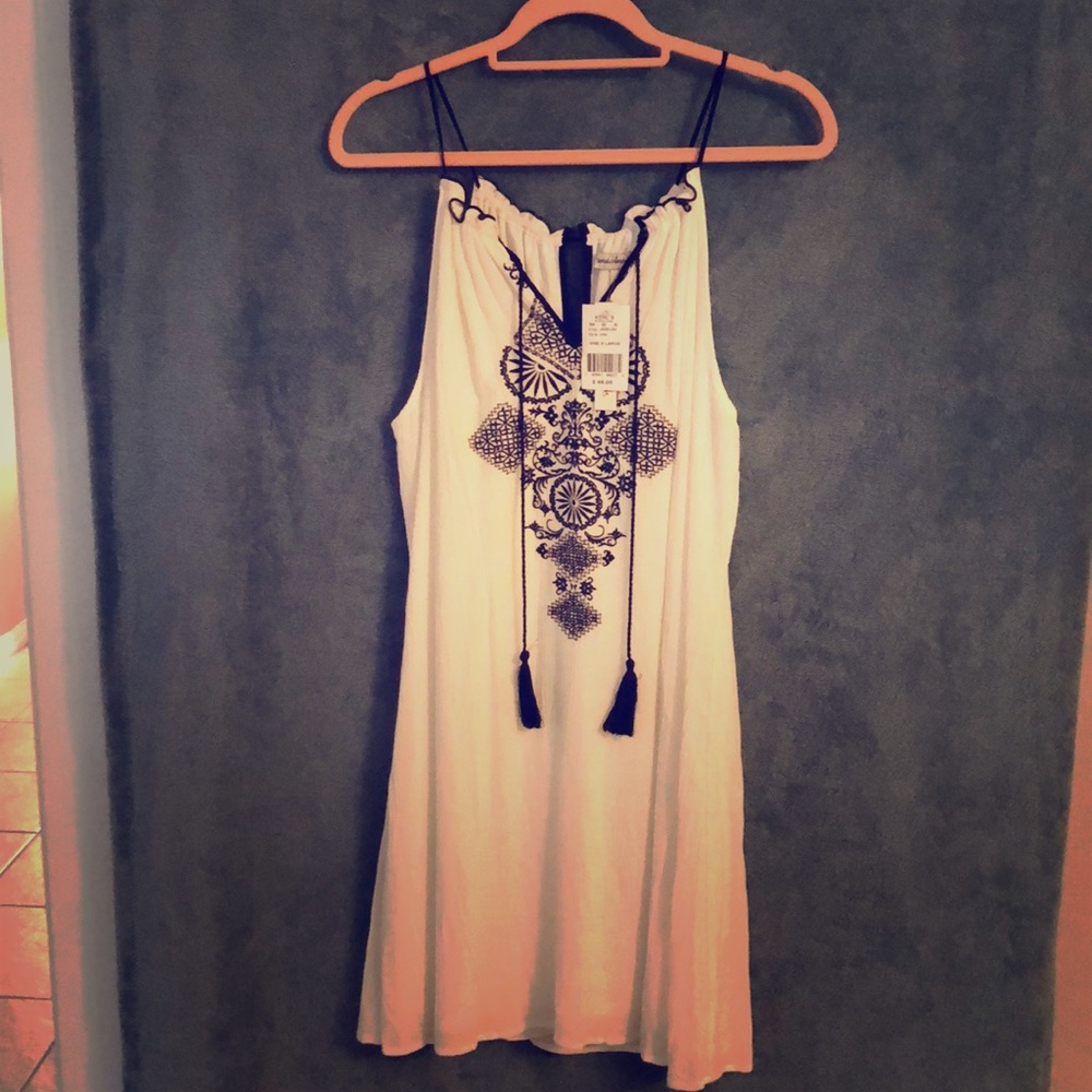 White sundress with black mosaic detailing.